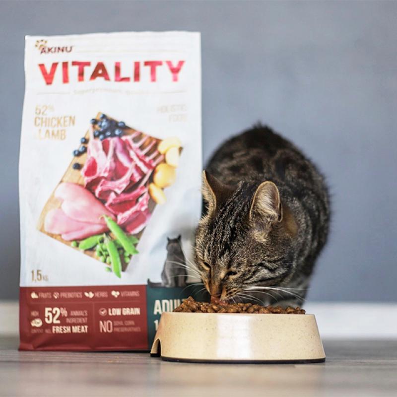 kočka jí ze své misky granule a vedle ní stojí pytel s krmivem Akinu VITALITY